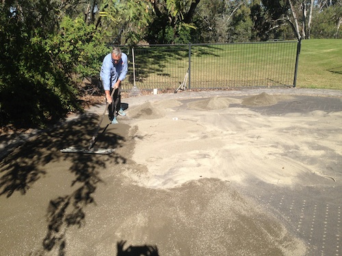 Adding the cement and crusher dust, then smoothing it out.